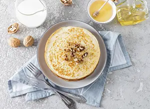 Traditional Russian Cuisine Drucke: Top view of a large stack crepes of with honey and walnuts