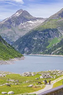 Blue Sky Mountain Lake View Drucke: View of a mountain lake with cyclists on a path