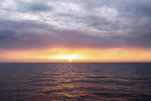 Setting Sun Over Sea Drucke: View across the open sea to the setting sun