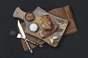 High Angle View Of Steak Drucke: Top view of pan seared beef steak on dark background