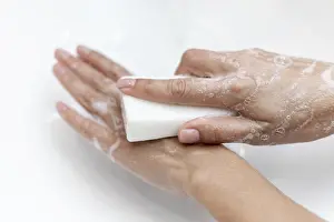 Personal Hygiene Habits Drucke: Top view person washing hands with solid soap