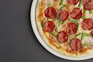 Pizza From Above Drucke: Top view of part of pizza pepperoni on black table