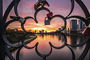 Evening Skyline View Drucke: View through a railing with love locks