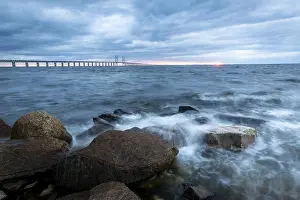Danish Coastal Scene Drucke: The view of the rough sea with a dramatic sky and a bridge in the background