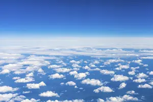 View From Above Drucke: View from above of many small clouds in the blue sky from the plane