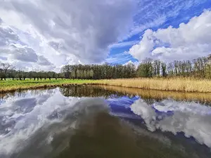 Cloudy Horizon View Drucke: View of small rain with dramatic cloud reflections and horizon line