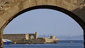 Greek Island Castle Drucke: View through a stone window arch to the sea and a small castle in the background