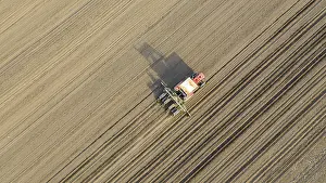 Cornfield Landscape Photo Drucke: Above top view, of tractor as pulling mechanical seeder machine over arable field