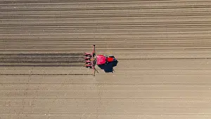 Grainfield Landscape Photo Drucke: Above top view, of tractor as pulling mechanical seeder machine over arable field
