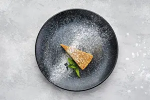 Bakery Products Still Life Drucke: Top view of triangular piece of caramel cheese cake on a plate