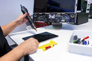Quality Inspection Process Drucke: Side view of an unrecognizable technician fixing a computer component using a soldering iron in a workshop