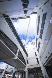 Contemporary European Design Drucke: View upwards into a modern building complex with blue sky and clouds