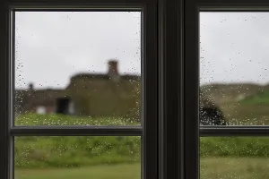 Gerahmter Druck : Blick durch Fensterscheiben mit Regentropfen, die sich zu Tropfen ballen.