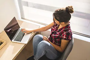 Working From Home Drucke: Top view of a young freelancer working from home using laptop