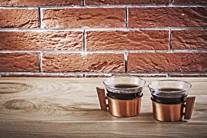 Close Up Coffee Cup Drucke: Two vintage copper cups with coffee on table