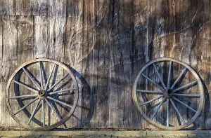 Deserted German Village Scene Drucke: Two wagon wheels leaning against a barn wall