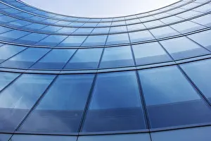 Modern Architecture Drucke: Wall of modern building with reflection of sky and clouds