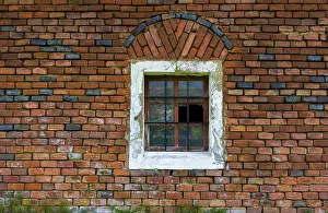 Deserted Austrian Village Drucke: Wall of red bricks with barred stable window and broken panes