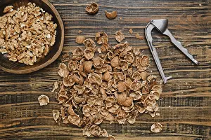Rustic Kitchen Setting Drucke: Walnuts are being shelled on a rustic wooden surface