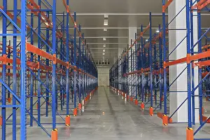 Empty Warehouse Storage Drucke: The warehouse is empty, with rows of blue and orange storage racks