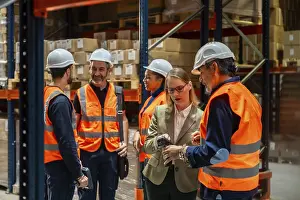 Warehouse Management Drucke: Warehouse manager and diverse workers standing together