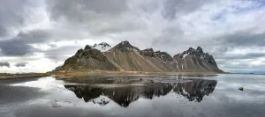 Mirror Image Of Mountains Drucke: Water reflection at the black sandy beach