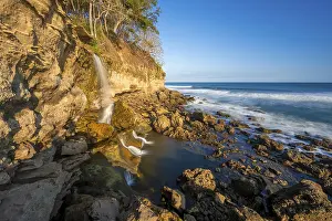 Rocky Cliff Coastline Drucke: Waterfall falls into the sea on the cliffs