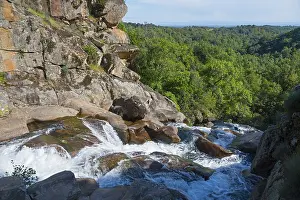 Extremadura UNESCO Site Drucke: A waterfall flows over rocks in a green