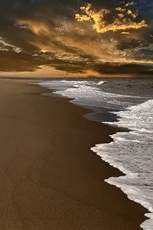 US American Coastal Landscape Drucke: Waves on empty beach, dramatic cloudy sky at sunset