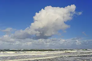 Cumulus Clouds Germany Drucke: Waves running out at the sandy beach