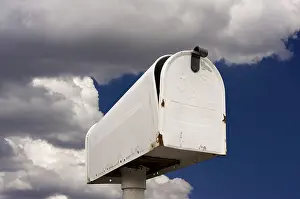Blue Sky Clouds Drucke: Weathered old mailbox against blue sky and clouds