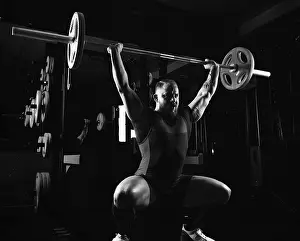 Young Weightlifter Drucke: Weightlifter does an exercise with a barbell