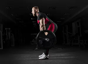 Weightlifting Training Drucke: The weightlifter performs an exercise called deadlift