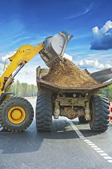 Construction Site Drucke: Wheel loadder loadding ground on tipper