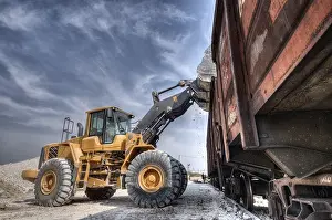 Deserted Building Site Drucke: Wheel loader excavator with backhoe unloading clay