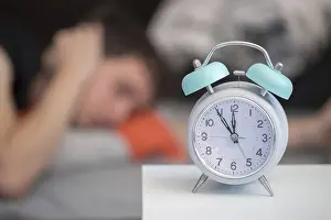 White Alarm Clock Drucke: White alarm clock on the bedside table