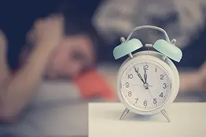 White Alarm Clock Drucke: White alarm clock on the bedside table
