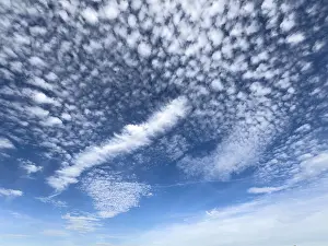 Weiße hohe Wolken in der oberen Hälfte des Bildes Cirrocumulus im Zentrum des Bildes.