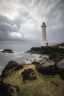 Bilder Datiert 3. Februar 2024: Weißer Leuchtturm an steilem Küstenabschnitt.