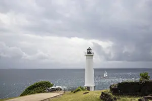 Drucke von Weißer Leuchtturm an steilem Küstenabschnitt. Dramatische Wolken mit Blick aufs Meer, reine Karibik am Le Phare du Vieux-Fort, auf Guadeloupe, Französische Antillen, Frankreich Guadeloupe Drucke: Weißer Leuchtturm auf steilem Küstenabschnitt.