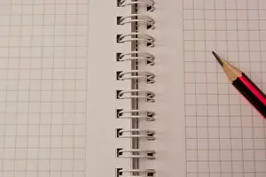 Back To School Supplies Drucke: White empty notebook with pencil on top of it