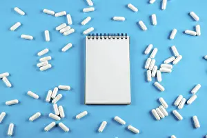 Plain Blue Background Image Drucke: White Notepad on a blue background with tablets