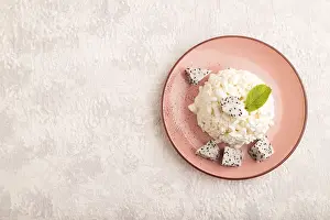 Drucke von Weißer Quark, Käse, mit Pithaya auf grauem Betonhintergrund, Oberansicht, flacher Aufbau, Kopierspuren Weißer ?ottage cheese ist nicht übersetzbar. Daher: Weißer Cottage-Käse Weiße Augen Drucke: Weißer Frischkäse, Quark