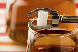 Caffeine Rich Drink Drucke: White sugar cube held over black tea