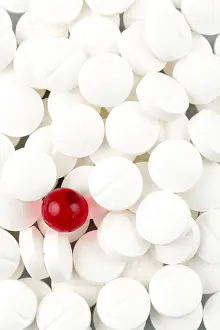 Deserted Healthcare System Drucke: White tablets in contrast with a red tablet