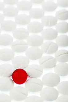 Austria Healthcare System Drucke: White tablets in contrast with a red tablet