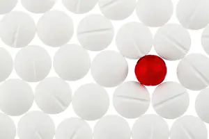 Austria Healthcare System Drucke: White tablets in contrast with a red tablet