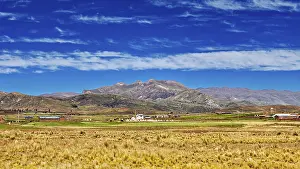 Bolivian Landscape Photography Drucke: Wide fields in front of a mountain range under a cloudy sky