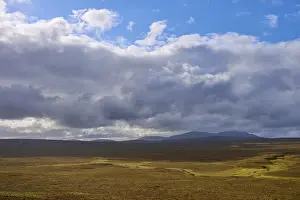 Northern Europe Countryside Drucke: Wide plain with cloudy sky and distant mountains in the background