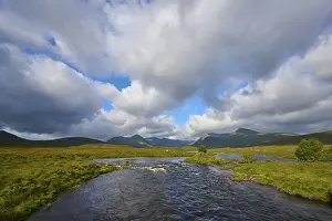 Cloudy Mountainous Landscape Drucke: Wide river landscape under dramatic clouds and mountains in the background